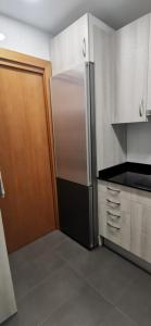 a kitchen with a refrigerator and a wooden door at Valencia habitaciones in Barcelona