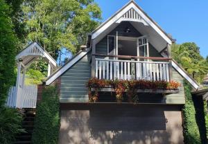 ein Haus mit einem Balkon mit Blumen darauf in der Unterkunft Mountain Studio Escape in Mount Tamborine