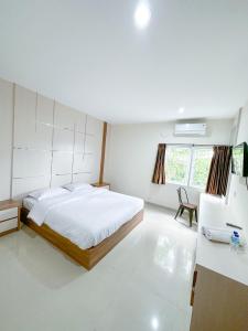 biała sypialnia z łóżkiem i umywalką w obiekcie Pillow Guest House w mieście Balikpapan
