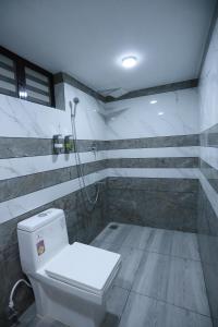 a bathroom with a toilet and a shower at Kausthubhom Residency in Tiruvalla