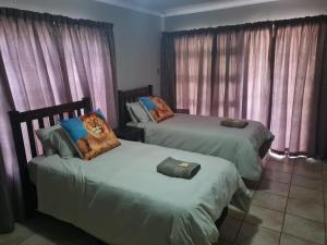 um quarto com 2 camas e uma almofada de gato em Huis Afrika em Vanderbijlpark