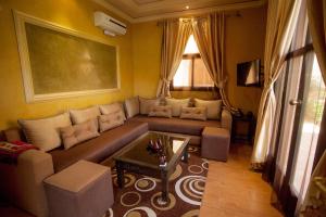 - un salon avec un canapé et une table dans l'établissement Luxurious apartment - secure and close to Marrakech, à Tahannaout
