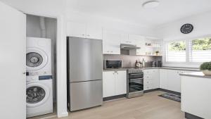 a kitchen with a refrigerator and a washer and dryer at 8 on Clarence in Moss Vale