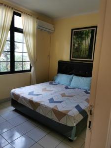 CikundulにあるVilla kota bunga 3 kamar bersih dan terawatの窓のある部屋にベッドがある寝室