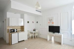 a kitchen with white cabinets and a tv in a room at Otilia in Bucharest