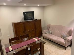 a living room with a couch and a tv at Los Naranjos Departamentos 2 in Concepción