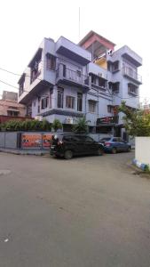 a black car parked in front of a white building at Satguru Homestays in Kolkata