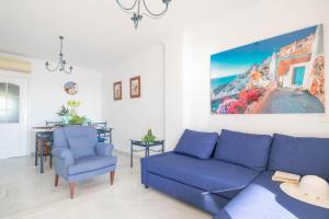 a living room with a blue couch and two chairs at Mi Capricho beach front sea view & pool - Happy Rentals in Mijas Costa