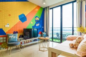 uma sala de estar com televisão e uma parede colorida em D'Pristine Theme Suite by Nest Home at LEGOLAND em Nusajaya