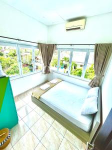 un grande letto in una stanza con finestre di Best Canggu Hostel a Canggu