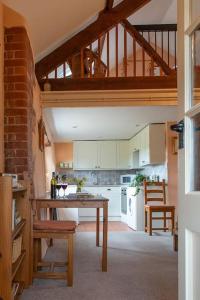 Highdown Farm Holiday Cottages في كولومبتون: مطبخ مع طاولة وكراسي في غرفة