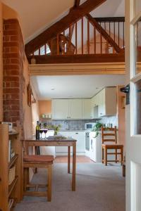 een keuken met een tafel en stoelen in een kamer bij Highdown Farm Holiday Cottages in Cullompton