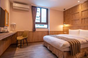 ein Hotelzimmer mit einem Bett, einem Schreibtisch und einem Fenster in der Unterkunft Shan Shui Hostel in Hualien