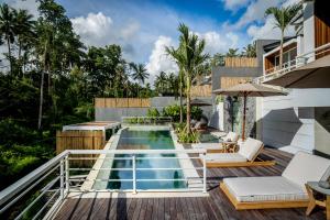 a swimming pool on a deck next to a house at Villa Mugiwara by BaliSuperHost in Ubud