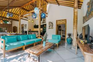 a living room with a blue couch and a table at Contemporary Balinese 4BR Private Villa in Umalas in Kerobokan