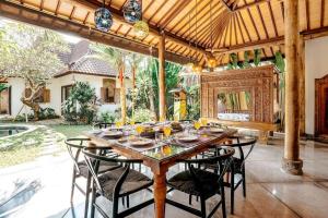 a dining room with a wooden table and chairs at Contemporary Balinese 4BR Private Villa in Umalas in Kerobokan