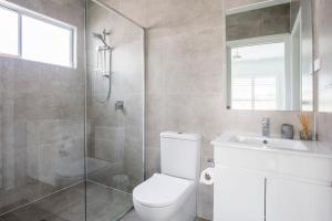 a bathroom with a shower and a toilet and a sink at Sanctuary Blue Pet Friendly 5 Mins to Hyams Beach in Sanctuary Point +15 photos