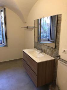 La salle de bains est pourvue d'un lavabo et d'un miroir. dans l'établissement Teatro Massimo Bellini appartamento nuovo2+3a/c, à Catane