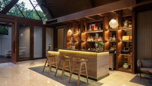 un bar in una stanza con sgabelli intorno di Plataran Komodo Resort & Spa - CHSE Certified a Labuan Bajo