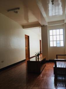 Casa de Milagrosa inn في كاليبو: غرفة فارغة مع طاولة و نافذة كبيرة