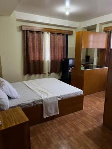 Casa de Milagrosa inn في كاليبو: غرفة نوم صغيرة مع سرير ومكتب
