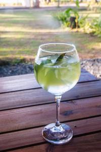 un bicchiere di vino bianco seduto su un tavolo di legno di Eco Sanctuaries Nature Lodge Nacpan Beach, El Nido a El Nido