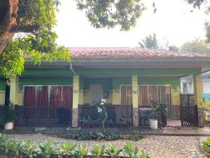 a yellow house with a gate in front of it at Angela's Pool Resort in Puerto Princesa City