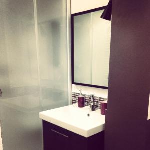a bathroom with a sink and a shower with a mirror at B&B Santiago in Gela