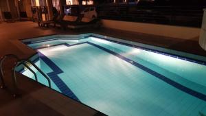 a large swimming pool with blue lighting in a building at Aris Studios in Hersonissos