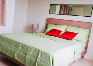 a bedroom with a large bed with red pillows at YokosoCEBU & Private Parking in Cebu City