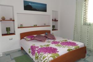 サンタンティーオコにあるThe Blue Lighthouseのベッドルーム1室(紫色の花のベッド1台付)