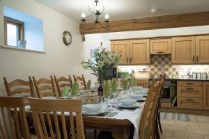 a dining room with a table with chairs and a kitchen at Coach House - detached cottage within 135 acres in Bromyard