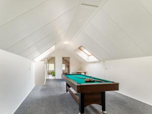 einen Billardtisch in einem Zimmer mit weißen Wänden in der Unterkunft Farmhouse in the Achterhoek with hot tub and beach volleyball in Megchelen