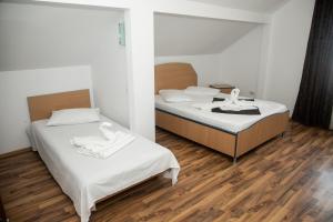 two beds in a room with wooden floors at Vile Mamaia Nord in Mamaia Sat/Năvodari
