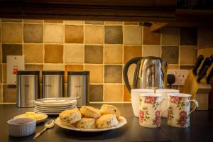 a plate of food on a counter with cups and plates at Coach House - detached cottage within 135 acres in Bromyard +36 photos