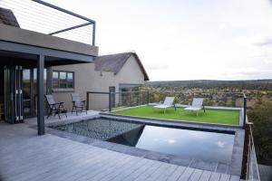 a house with a swimming pool on a deck at Tadima Lodge Mabalingwe in Mabula