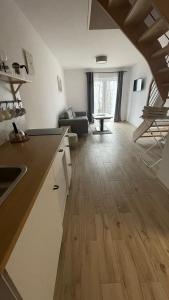 cocina y sala de estar con suelo de madera en Dwupoziomowe Apartamenty Leszczyna en Ustroń