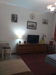 ein Wohnzimmer mit einem TV auf einer Holzkommode in der Unterkunft Apartman Sanin in Sarajevo