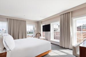 a bedroom with a white bed and two windows at 33 Seaport Hotel New York in New York