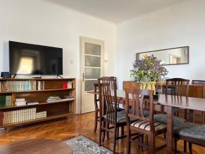 a dining room with a table and chairs and a tv at Apartment Mirna - what you see is what you get in Opatija