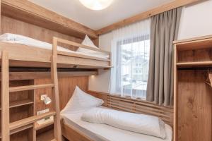 フェントにあるAppartements Zirmhofの二段ベッドと窓が備わる小さな客室です。