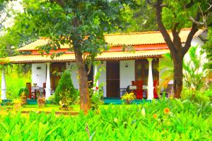 una pequeña casa blanca con techo naranja en Panoramic Royal Villa, en Sigiriya