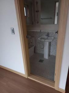 a bathroom with a sink and a mirror at Summer's House in Jeju