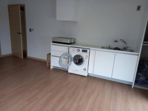 uma máquina de lavar roupa e um lavatório num quarto em Summer's House em Jeju