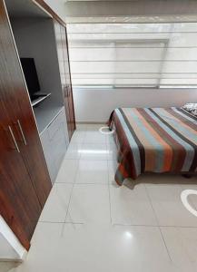 Habitación pequeña con cama y ventana en Puerto santa Ana 2 habitaciónes, en Guayaquil