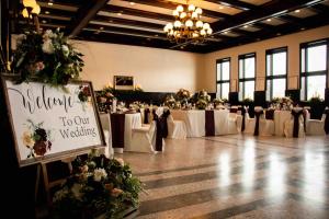 un salón de banquetes con mesas blancas y sillas con flores en Yogo Inn, en Lewistown