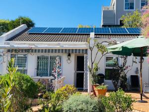 a white house with solar panels on the roof at Sunbird in Hout Bay
