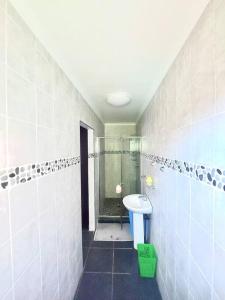 a bathroom with a shower and a toilet and a sink at Morningview Cottage in Durban