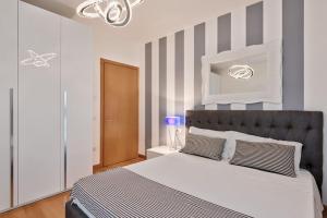 una camera da letto con un grande letto con pareti a righe di Modern Apartment Casa Mia Easy to Venice a Treviso