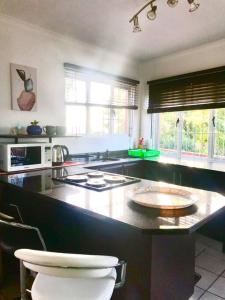 een keuken met een groot eiland met een aanrecht bij Morningview Cottage - Self Catering Private Owned Rental in Durban +8 foto's